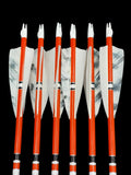 Six wooden arrows with bright orange shafts, white fletching with black and gray patterns, and white nocks, arranged vertically against a black background. The arrows feature black, white, and orange bands near the fletching, adding a striking contrast to their design.
